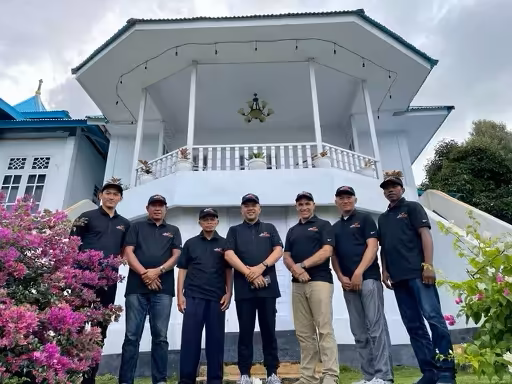 Our proud tea company team standing in front of a beautifully designed building, united in their mission to deliver the finest quality ingredients to you.