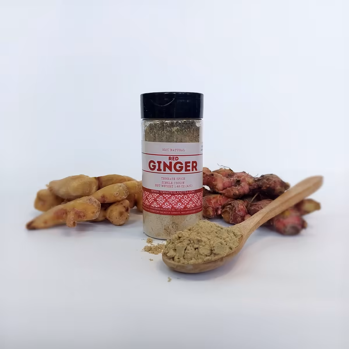 A spice bottle of Red Ginger powder with a sleek label reading ‘Ternate Spice, Single Origin,’ displayed on a bed of red ginger powder.